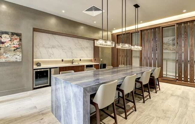 a large kitchen with a marble counter top and a long table
