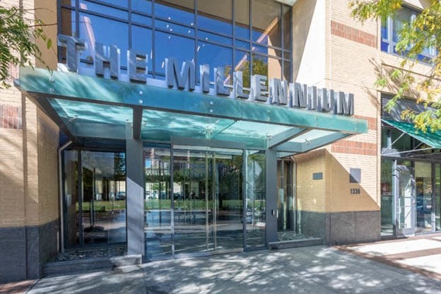 a building with a large glass door and a green awning at The Millennium, Arlington