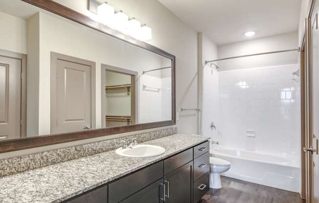 a bathroom with a large mirror and a white sink
