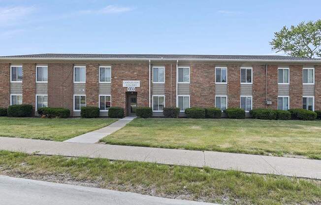 a brick apartment building with a sign on the front