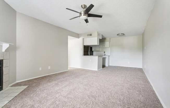 A room with a ceiling fan and a carpeted floor.