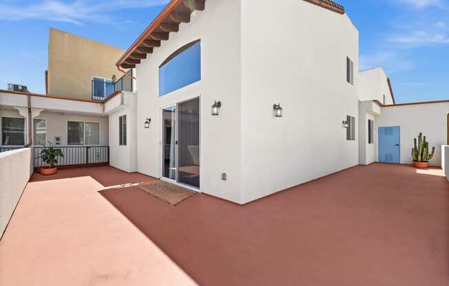 a white house with a patio and a blue door