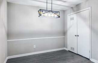 an empty room with white walls and a door and a chandelier