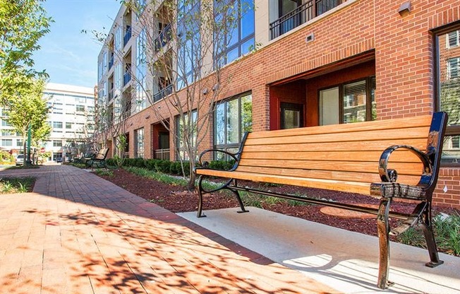 a wooden bench sitting in front of a brick building