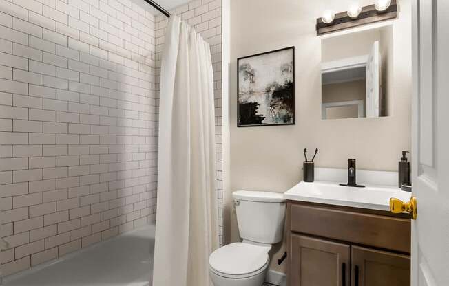 a bathroom with a toilet and a sink and a shower