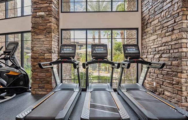 A gym with treadmills and a brick wall. at The Laurel Apartments, Chandler, 85286
