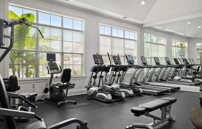 A gym with treadmills, exercise bikes, and other equipment.