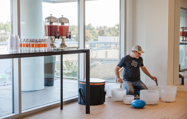 a man in a blue shirt and a white hat is kneeling on a wooden floor and is