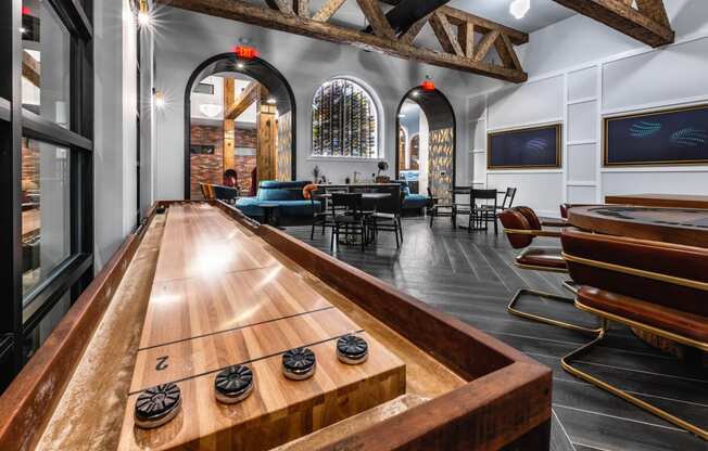 a bar with a shuffleboard table in the center of a room with a table