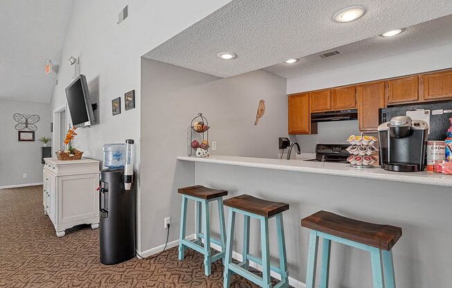 a kitchen with three stools in front of a bar