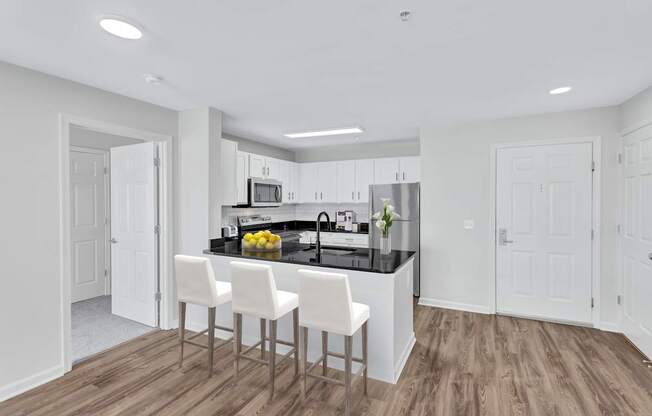 a kitchen with white cabinets and a black counter top