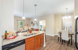 a kitchen with a sink and a dining room with a table