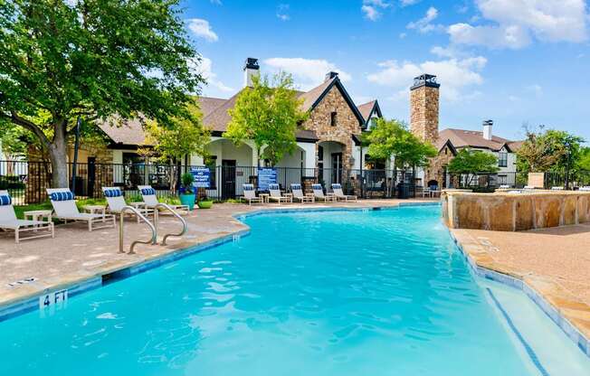 Resort-style swimming pool with expansive deck seating and clubhouse views in Lewisville, TX.