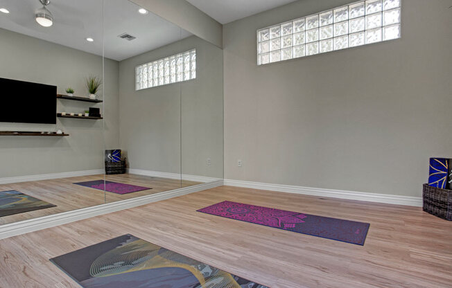 A practical kitchen here at Sonoma Landing featuring light wood cabinetry, a full appliance setup including a refrigerator, range, microwave, and dishwasher, and wraparound countertops with a double-basin sink, complemented by wood-style flooring, neutral walls, and an open pass-through that connects the kitchen to the adjacent living space.