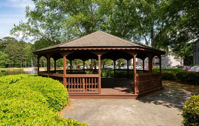 a gazebo in a park next to a pond