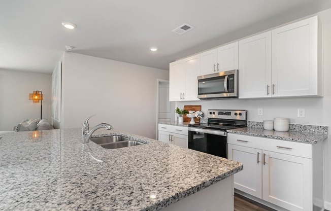 a kitchen with white cabinets and granite countertops