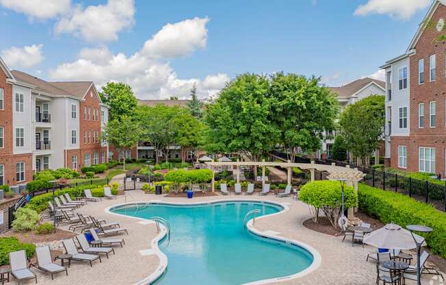 A large swimming pool surrounded by lounge chairs and umbrellas.