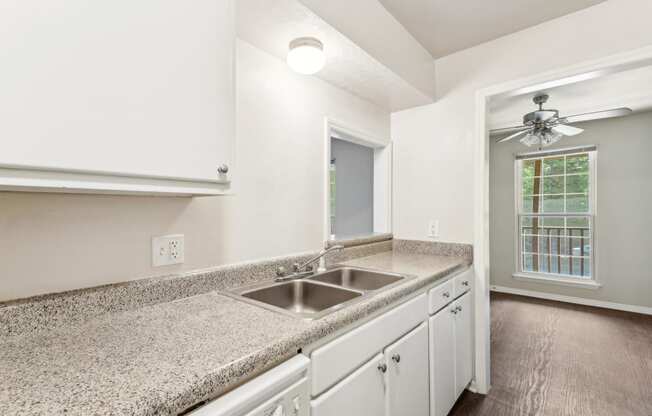 a kitchen with white cabinets and granite counter tops and a sink