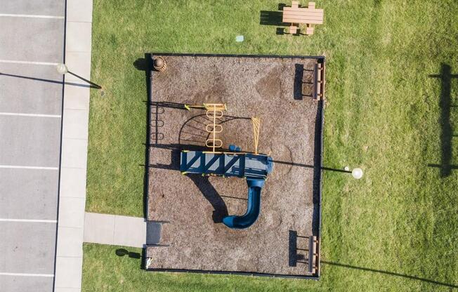 an aerial view of a blue playground equipment in a field at The Maddox Apartments, Centerton, AR
