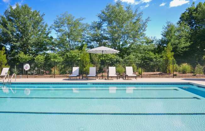 a swimming pool with chairs and an umbrella