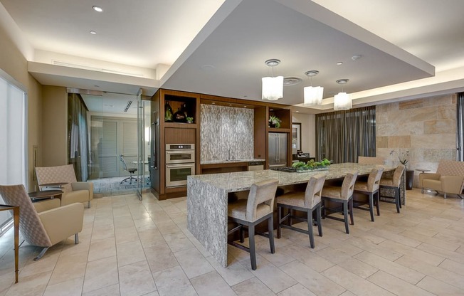 a large kitchen with a long counter and chairs