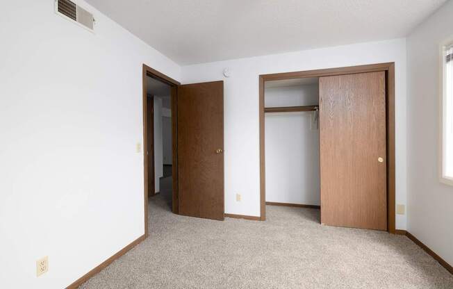 A room with two doors and a carpeted floor.
