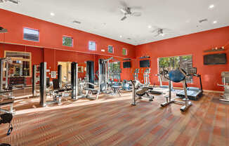 A gym with a variety of equipment including treadmills, weights, and exercise machines.