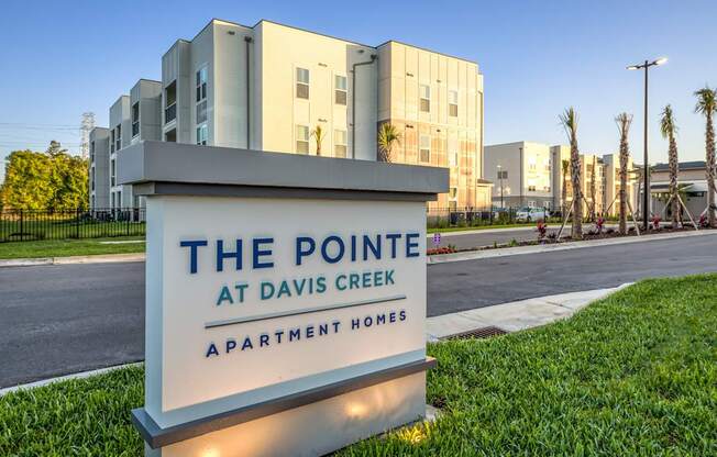 A sign for The Pointe at Davis Creek Apartment Homes is in front of a building.