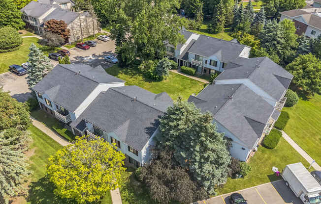 A large house with a grey roof surrounded by trees.