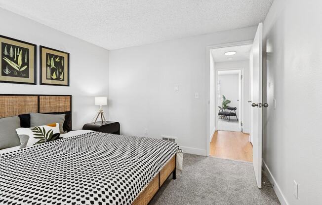 A bedroom with a bed, nightstand, and two pictures on the wall.