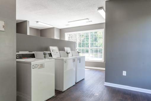 A laundry room with two washing machines and a window.