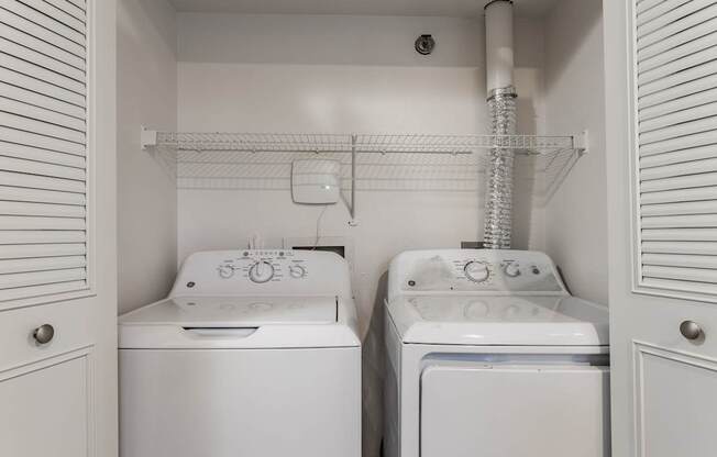 A small laundry room with a washer and dryer.