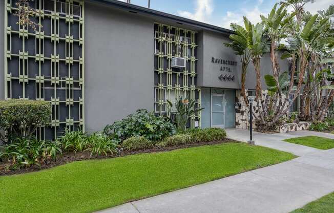 a building with a lawn and trees in front of it