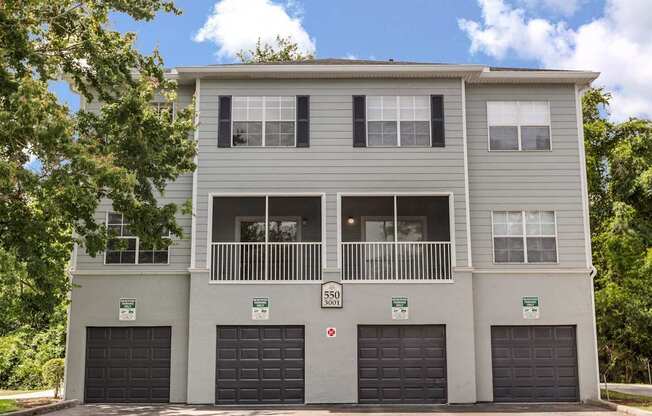 A grey two-story building with a balcony on the second floor.