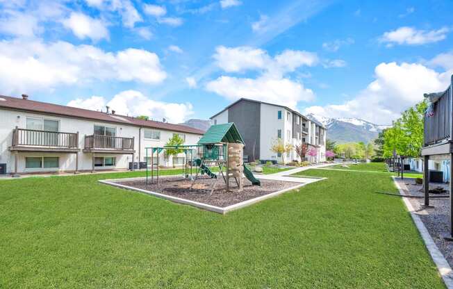 a park with a playground in the middle of some apartments
