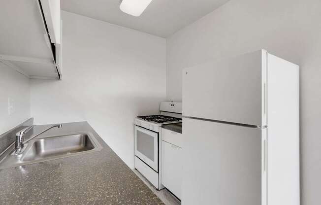 A kitchen with white appliances and a granite countertop.