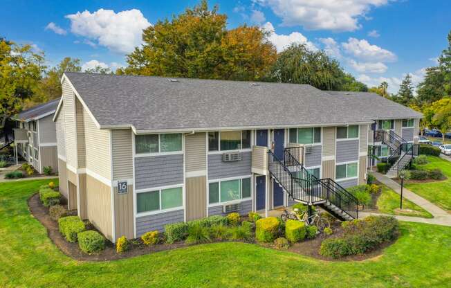 Elevated drone shot of the Pinecrest exterior community and two story building with pretty blue front doors. at Pinecrest Apartments, Davis, California