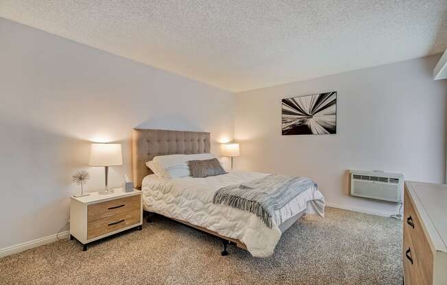 a bedroom with a bed and a dresser with a nightstand