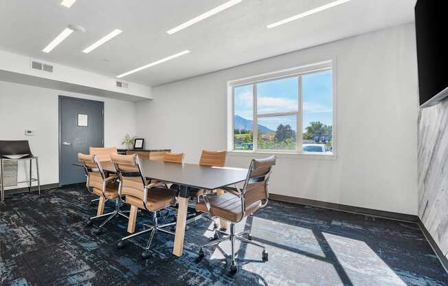 a conference room with a table and chairs and a window