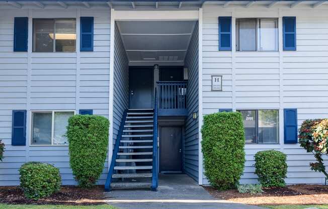 a blue and white building with blue shutters and a blue staircase Copper Ridge Apartments, Renton, 98055