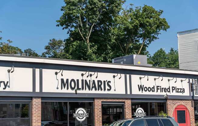 A Molinaris wood fired pizza restaurant with a car parked in front.