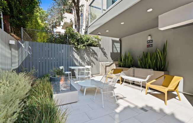 a patio with chairs and tables and a blue fence