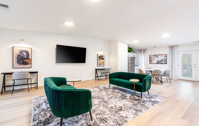 A living room with a green chair and a black television.