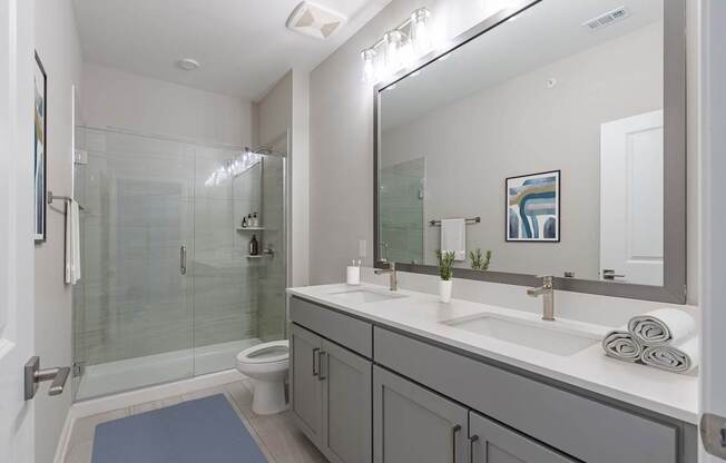 A bathroom with a toilet, sink, and mirror.