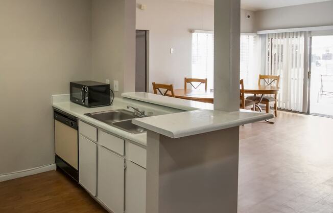 an empty kitchen with a sink and a microwave