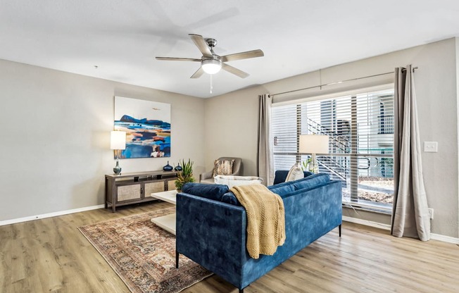 a living room with a blue couch and a ceiling fan at Reserve at Temple Terrace, Temple Terrace