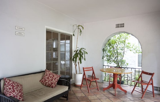 A balcony with a table and chairs.