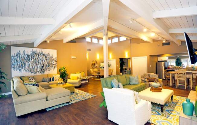 A living room with a white couch and a painting on the wall.