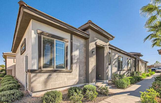 Building with bushes and a sidewalk at Hampton Meridian, Apache Junction, AZ
