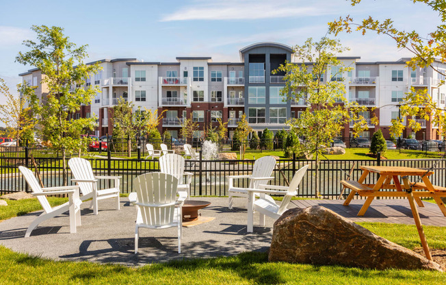 an outdoor patio with chairs and tables in front of an apartment building